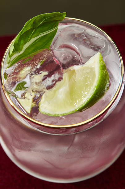 Close up view of of refreshing mojito with mint and ice in glass with golden rim isolated on grey - Foto, afbeelding