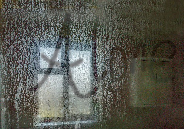 λέξη ΜΟΝΟΣ, γραμμένο σε μια καυτή οθόνη ντους με θέα προς ένα παράθυρο στη ρύθμιση μπάνιο. - Φωτογραφία, εικόνα
