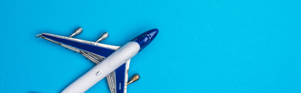 Vista superior del avión de juguete sobre fondo azul, plano panorámico
 - Foto, Imagen