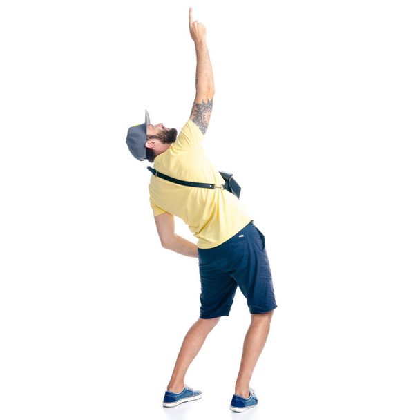 Man in shorts and cap standing looking hands up showing pointing - Foto, Imagem