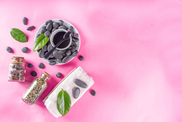Flat lay composition with spa stones, green leaves and cosmetics, top view copy space - Фото, изображение