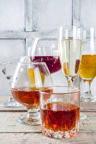 Farklı alkollü içecekler. Bira, kırmızı beyaz şarap, martini, şampanya, konyak, çeşitli bardaklarda viski. - Fotoğraf, Görsel