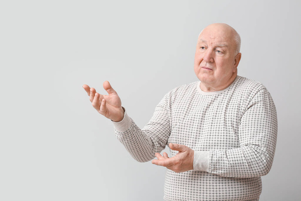 Homem idoso portador de deficiência mental em fundo cinzento - Foto, Imagem