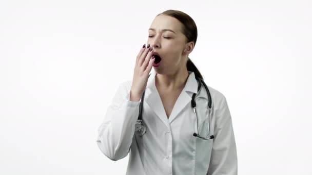 Tired doctor yawns, put on portable neck pillow for nap or snooze, closes eyes - Footage, Video