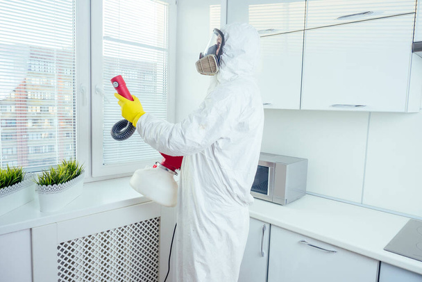 white worker spraying pesticide on induction hob - 写真・画像