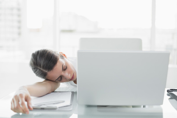 Pretty exhausted businesswoman sitting at her desk sleeping - Photo, image