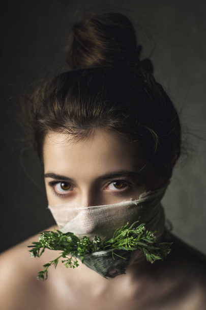 Naamioitunut tyttö sepelvaltimotautipandemian aikana. Naamioitu tyttö vihreitä kukkia
 - Valokuva, kuva