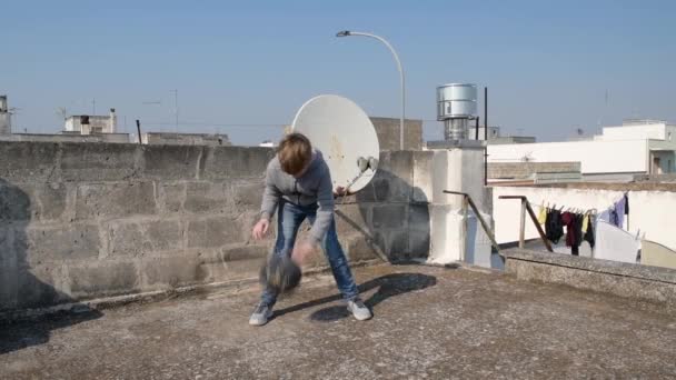 Хлопчик дриблінг м'яча на даху свого будинку під час карантину коронавірусу ковід-19. Дитячий кошик, щоб залишатися здоровим. Ідея діяльності дітей домашніх тренувань, карантинного спорту
 - Кадри, відео