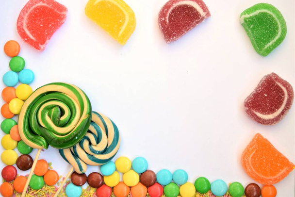 marco para escribir y celebrar en días festivos y ocasiones especiales, hecho de caramelos de colores en un piso blanco y de madera
 - Foto, Imagen