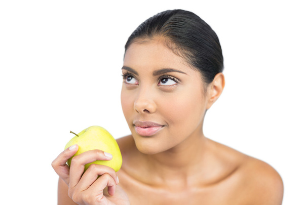 Calm nude brunette holding green apple - 写真・画像