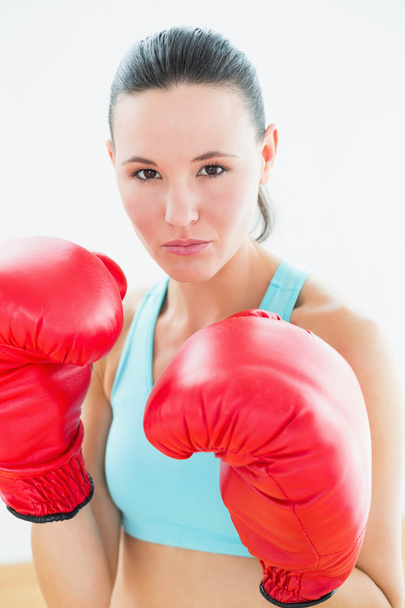 Close-up portrait of a beautiful woman in red boxing gloves - Foto, afbeelding