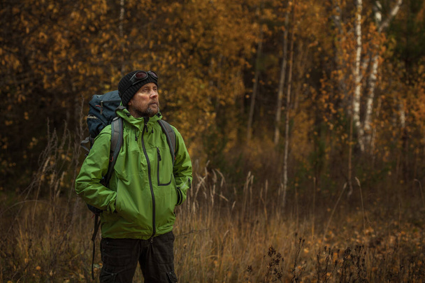Mature backpacker in an autumn forest - Фото, изображение