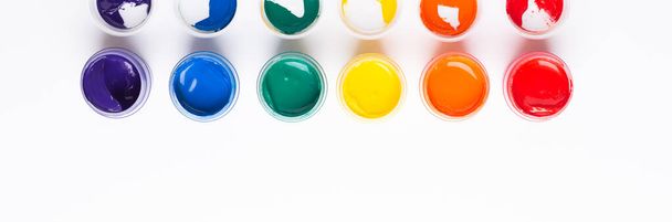 Multicolored gouache on a white background Isolated Paints in containers Top view Copy space Banner Horizontal - Fotó, kép