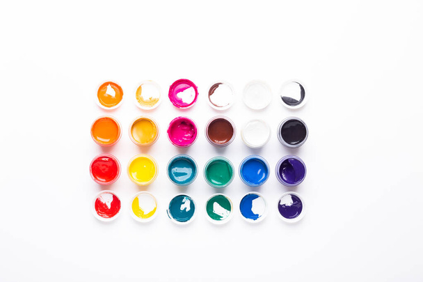 Multicolored gouache on a white background Isolated Paints in containers Top view Copy space - 写真・画像