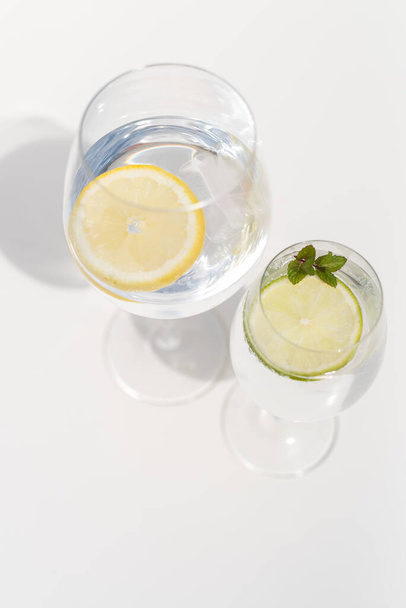 Sparkling water in the wine glass with ice and lemon  - Foto, immagini