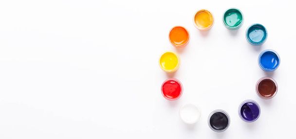 Multicolored gouache on a white background Circle shape Isolated Paints in containers Top view Copy space Banner Horizontal - Photo, Image