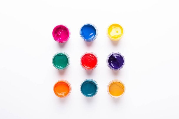 Multicolored gouache on a white background Isolated Paints in containers Top view Copy space - Fotoğraf, Görsel