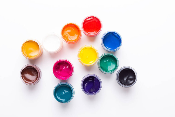 Multicolored gouache on a white background Isolated Paints in containers Top view Copy space - Foto, Bild
