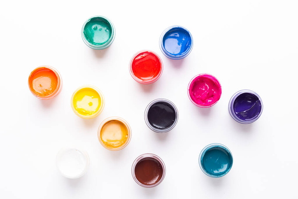 Multicolored gouache on a white background Isolated Paints in containers Top view Copy space - Foto, afbeelding