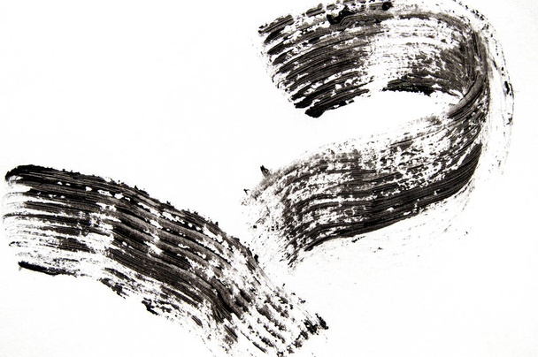 Mancha muestra de rímel negro aislado sobre un fondo blanco, concepto de belleza
. - Foto, Imagen