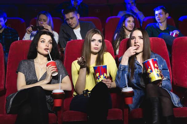 Κορίτσια που βλέπουν μια πολύ βαρετή ταινία στο σινεμά. Κακή ταινία. - Φωτογραφία, εικόνα