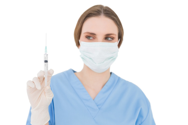 Young brunette physician holding a syringe - Фото, изображение
