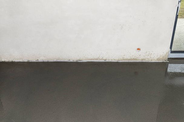 Zavlažování čerstvě nalité podlahové stěrky doma, aby se zabránilo prasknutí. - Fotografie, Obrázek