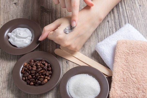 Kobieta nakłada naturalny peeling na skórę. Domowej roboty peeling z cukru, soli, śmietany i kawy. Piękno, Spa, pielęgnacja skóry, aromaterapia. Nawilżanie, złuszczanie, złuszczanie - Zdjęcie, obraz