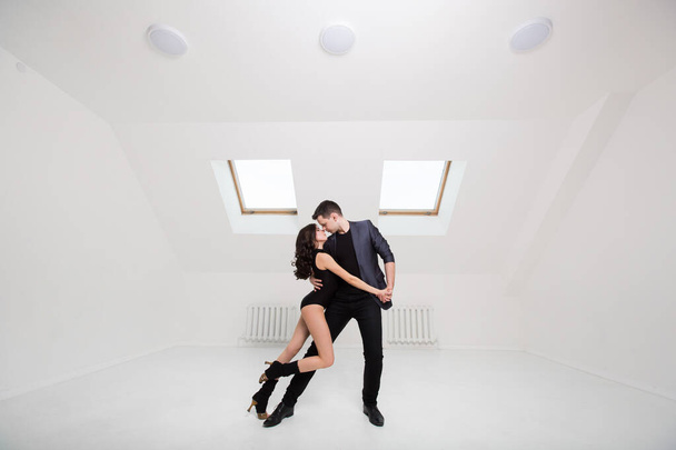 beautiful couple dancing bachata on white background in studio. - Foto, afbeelding