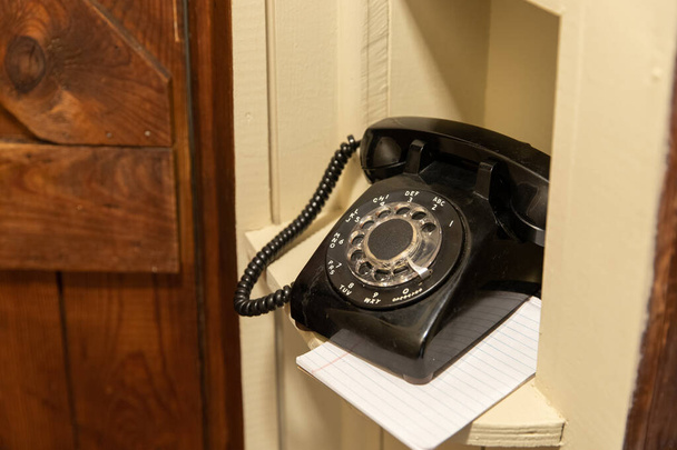 Παλιά μαύρο περιστροφικό τηλέφωνο στο διάδρομο τηλέφωνο γωνία - Φωτογραφία, εικόνα