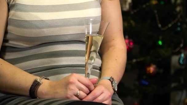 Una chica con una copa de champán en el fondo de un árbol de Navidad
 - Imágenes, Vídeo