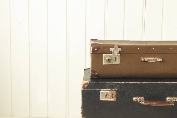 Two old retro suitcases White wooden background Vintage tinting Copy space - Zdjęcie, obraz