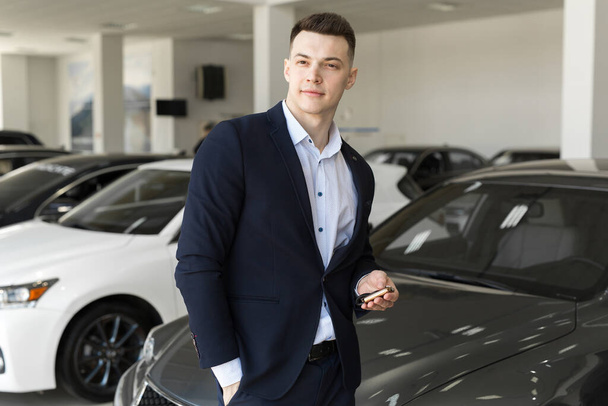 Handsome man choosing a car in a show room. - Photo, Image
