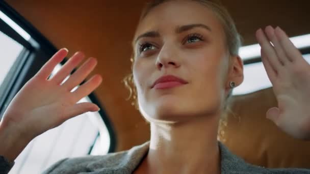 Portrait of pretty businesswoman dancing in car. Girl moving hands in modern car - Záběry, video