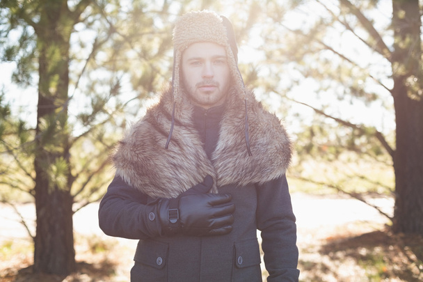 Handsome young man in warm clothing standing in forest - Foto, Imagem