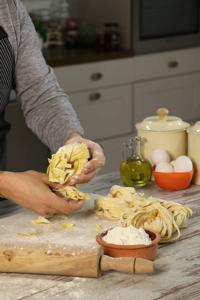 Мужской руки видели делать макароны с тестом ролика и муки на кухне счетчик
 - Фото, изображение