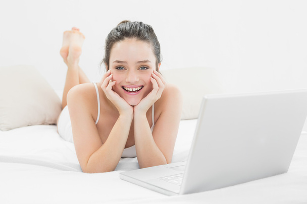 Smiling casual woman with laptop in bed - Fotoğraf, Görsel