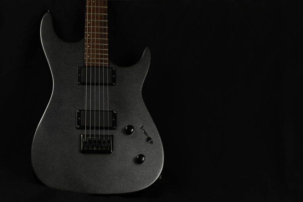 Chitarra elettrica grigia su sfondo nero, spazio di copia
 - Foto, immagini