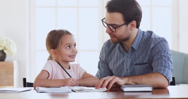 Young father helping little cute kid daughter with homework. - Záběry, video
