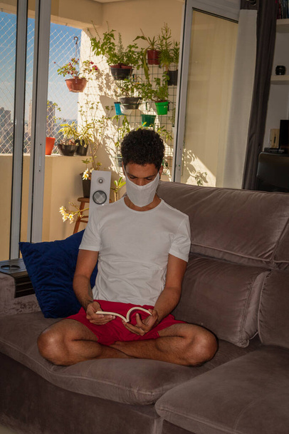 Man met beschermend masker tegen het coronavirus in eigen quarantaine. - Foto, afbeelding