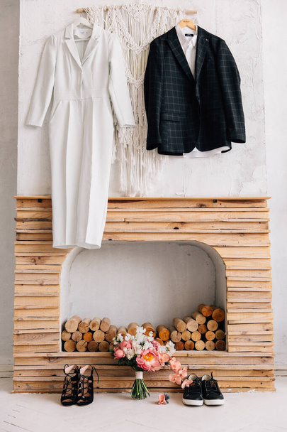 свадебная одежда пары, висящей у камина в скандинавском стиле объятия
 - Фото, изображение