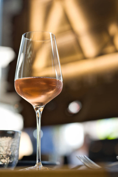 Bicchiere con vino rosato freddo su un tavolo servito
 - Foto, immagini