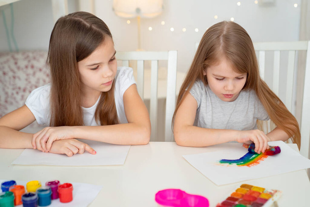 two sisters drawing rainbow. stay at home. - Fotoğraf, Görsel