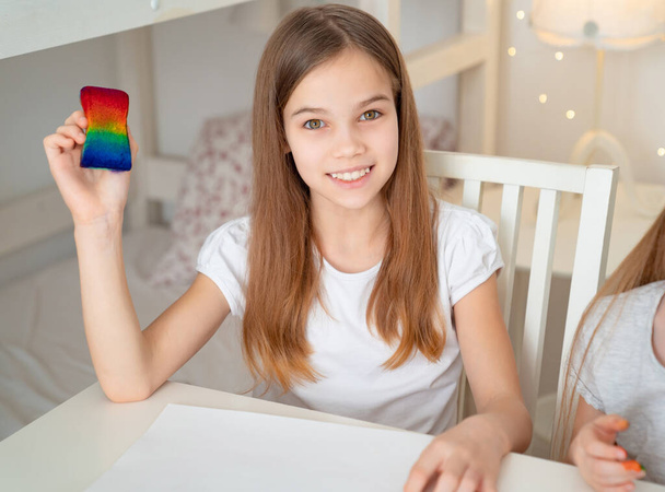 teen girl drawing rainbow. stay at home. - Фото, изображение