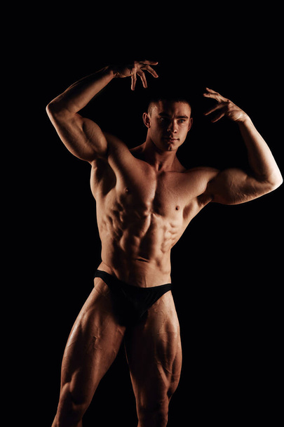 Strong men posing and showing muscles. Great shape before championship. Perfect for sport nutrition promo. Athlete and bodybuilder. Close-ups. Black background.  - Foto, immagini