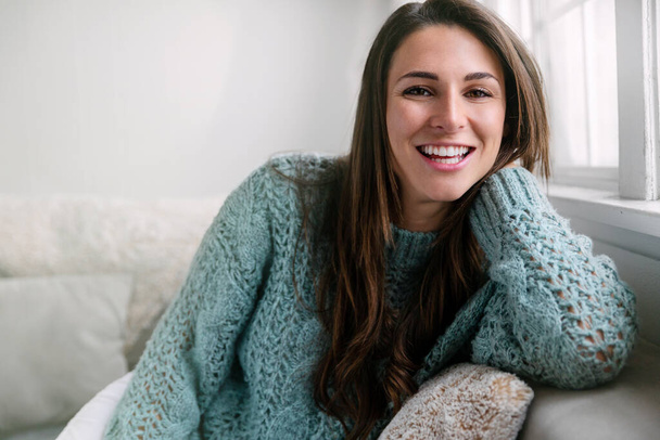Випадкова красива жінка сидить розслаблена вдома на дивані, ідеальна посмішка, портрет прямих білих зубів
 - Фото, зображення