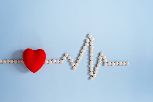 cardiogram medical pills and toy red heart on a blue background. healthy heart concept. Cardiology. Soft selective focus. - Photo, Image
