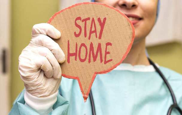 médico mulher segurando cartão de cartão com ficar em casa. Novel coronavirus - 2019-nCoV concept
 - Foto, Imagem