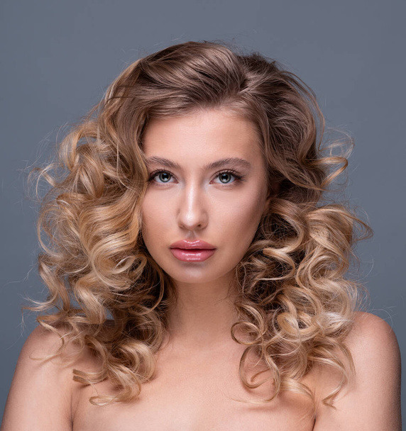 Beautiful girl with curly blond hair and flawless skin - Fotó, kép