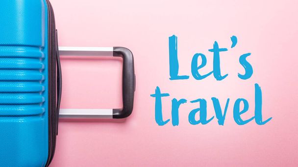 Words Let's Travel Blue suitcase on pastel pink background Summer holidays, vacation, travel concept Banner Minimal Copy space - Foto, afbeelding